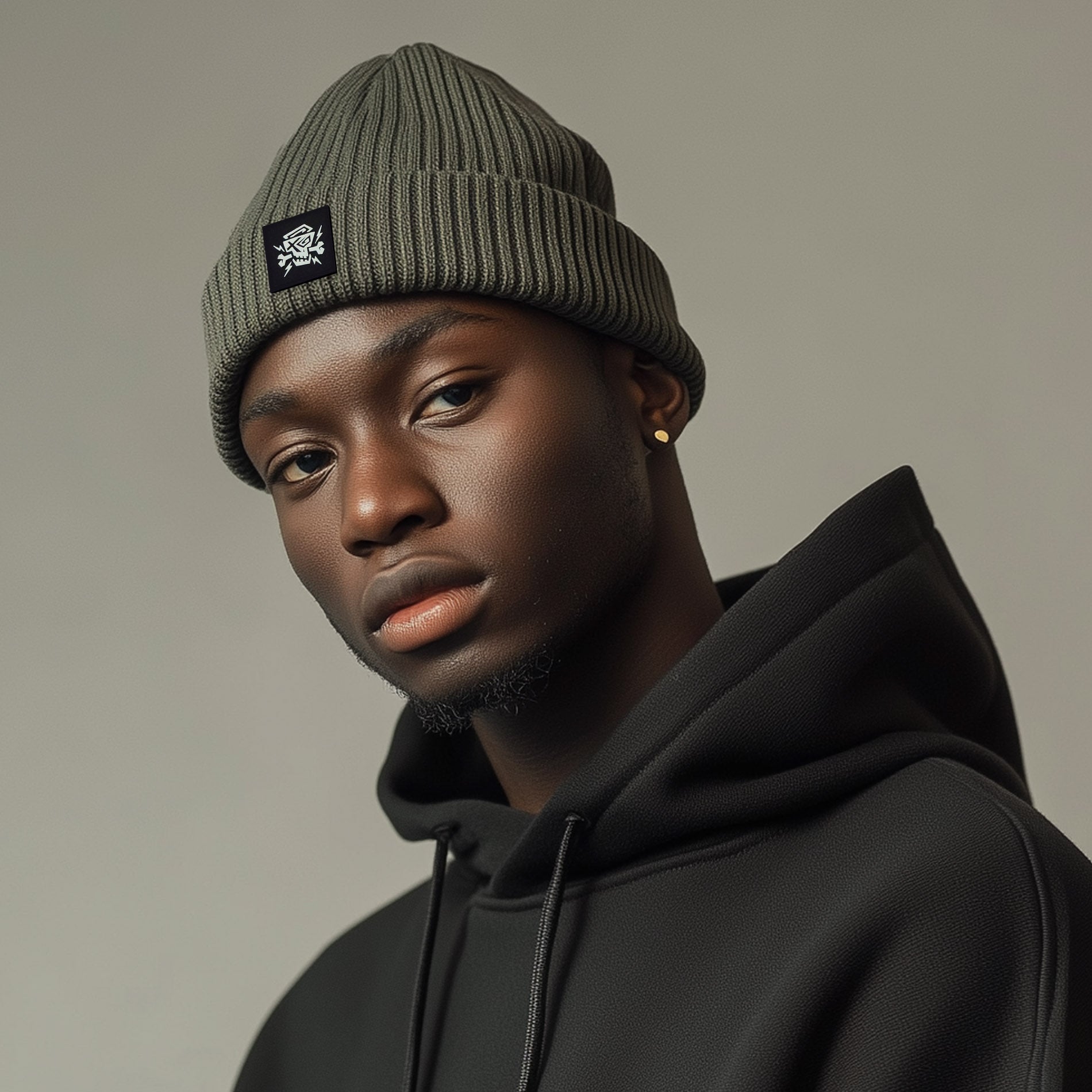Mann trägt das PsychoLab Beanie mit Black Patch – Recycled Edition in Olivgrün, perfekt für einen urbanen Streetwear-Look, hergestellt aus 100 % recyceltem Polyester. PsychoLab.