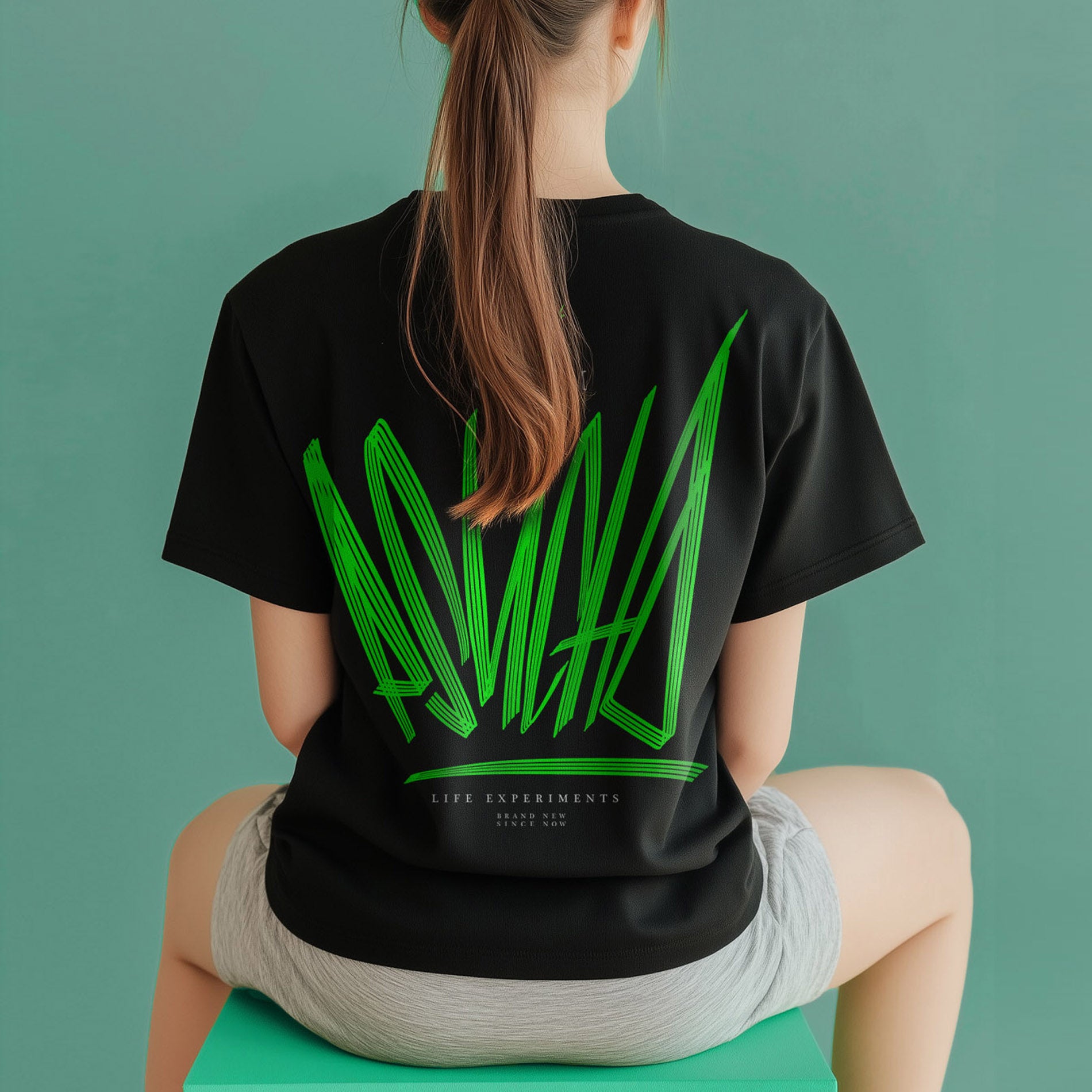 Das Women Shirt Dynamic von PsychoLab, getragen von einer Person, zeigt die auffällige grüne Typografie auf der Rückseite. Dieses stilvolle Streetwear-Shirt kombiniert minimalistisches Design mit nachhaltigen Materialien und ist perfekt für modebewusste Frauen.