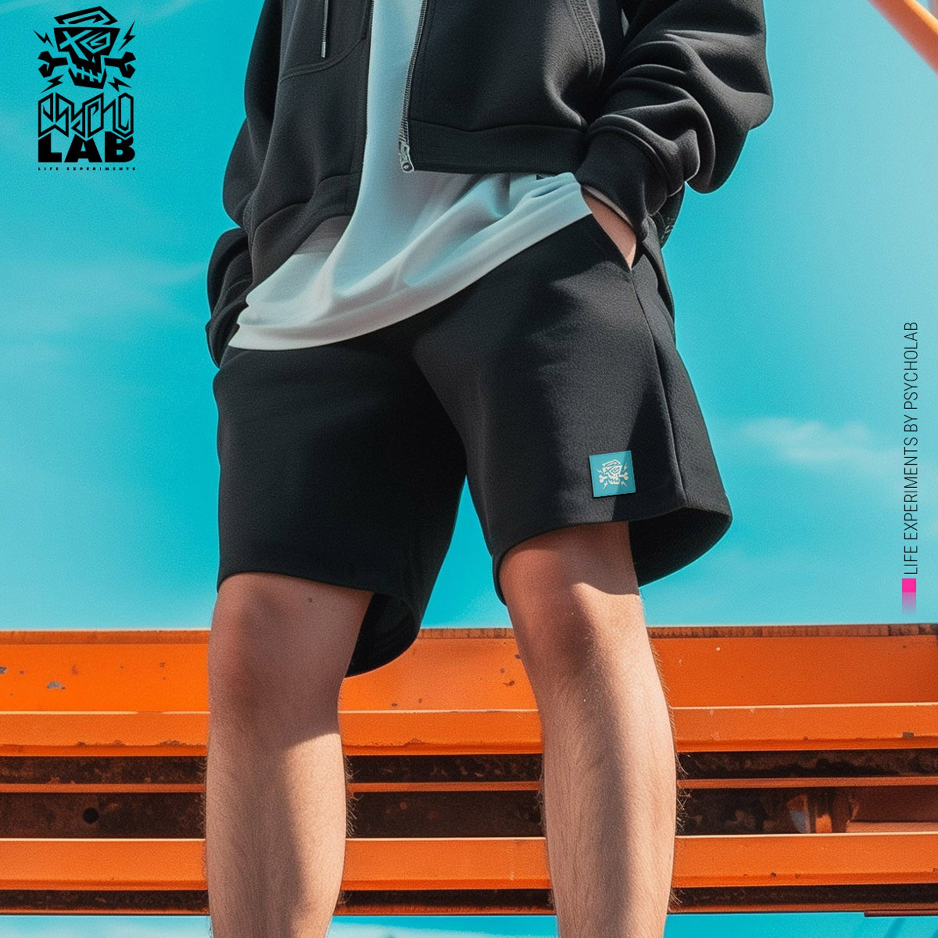 Schwarze PsychoLab Shorts mit blauem Logo getragen von Model – lässiger und urbaner Look.