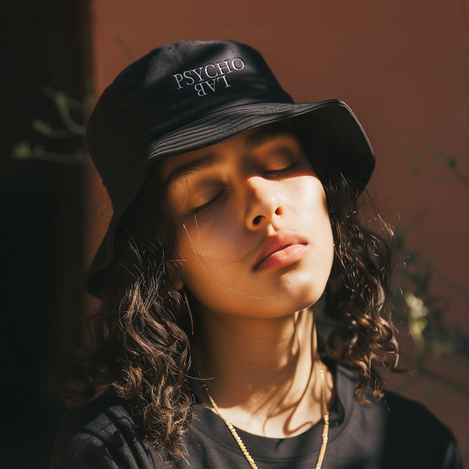 Model mit schwarzem Bucket Hat und PsychoLab Schriftzug.